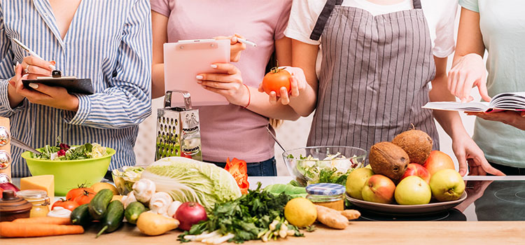 team of women surveying a table of fresh fruits and vegetables