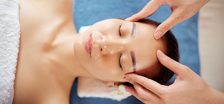 woman client having temples massaged by therapist