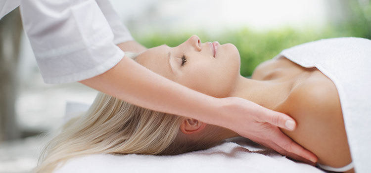 reclining woman having massage therapy on shoulders