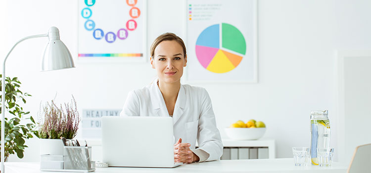 young woman at desk with food charts
