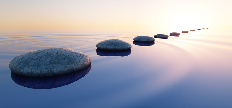 rippled pond with line of flat stones receding into distance