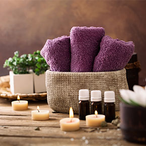 rolled towels arranged with candles and oils