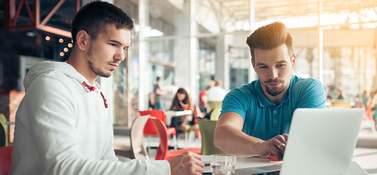 two men taking class on laptop