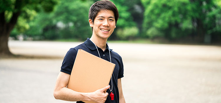 male athletic trainer with files in binder