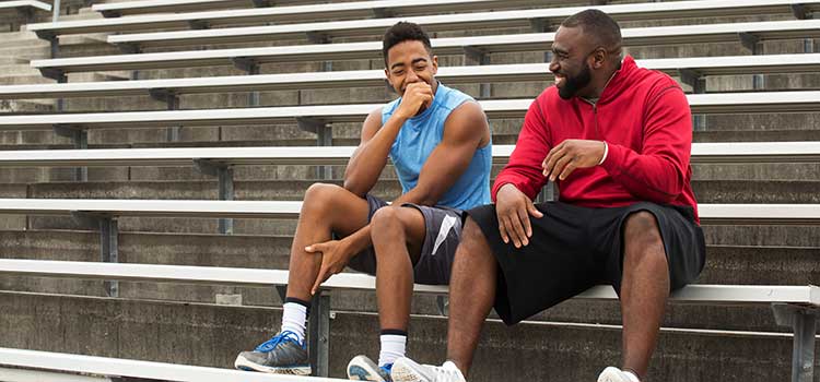 male athletic trainer talking to student athlete