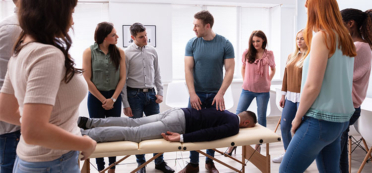 chiropractic instructor demonstrates back adjustment to class