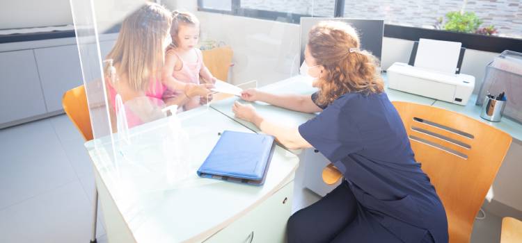 pediatric-nutritionist-handing-mother-and-child-a-document