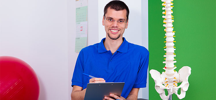 man with clipboard stands next to spine display