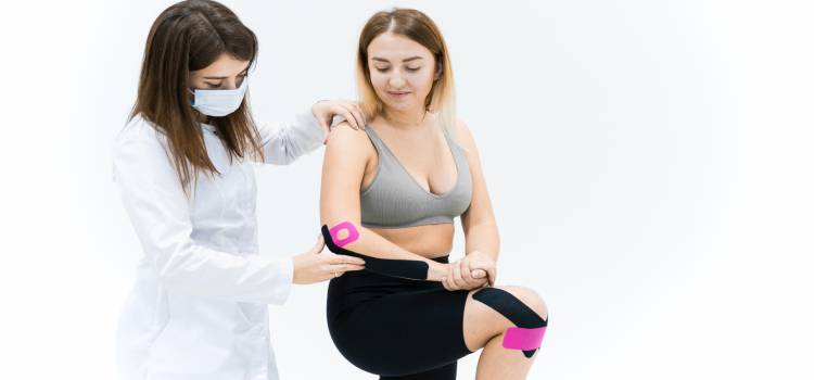 Registered Kinesiotherapist applying tape to a patients right elbow and knee