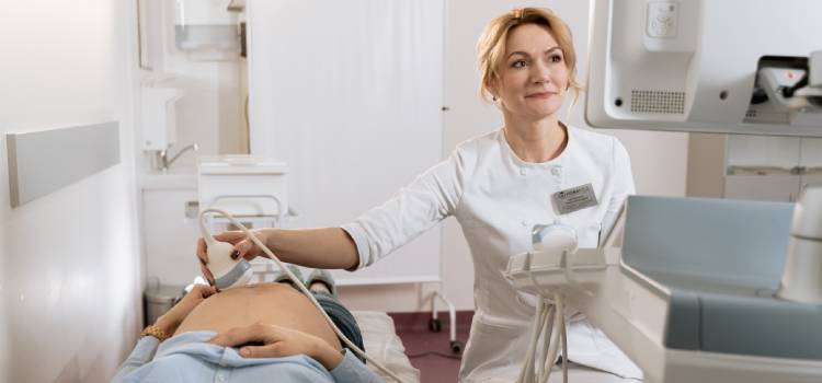 an obgyn conducting an ultrasound on pregnant woman at hospital