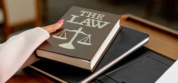 female-hand-extending-a-book-title-the-law