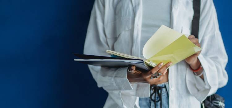 person-standing-reading-study-material-for-exam