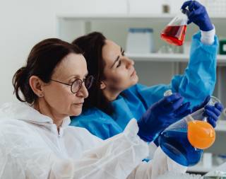 two female food scientists in a laboratory examining colorful liquids