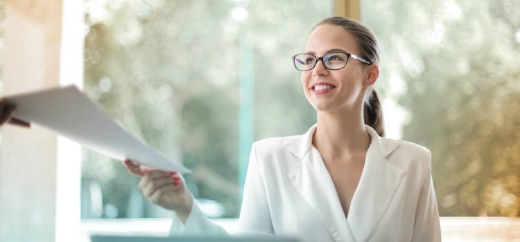 woman with glasses smiles as she receives her holistic health certification