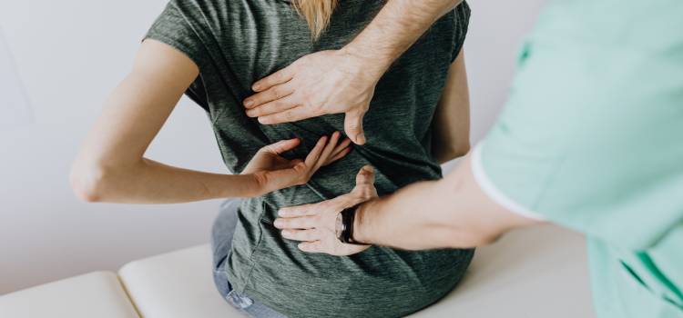 doctor of osteopathic medicine examining female patients midback