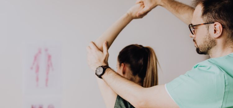 doctor of osteopathic medicine lifting patients arm during a session