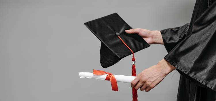 graduate extending diploma and graduate hat