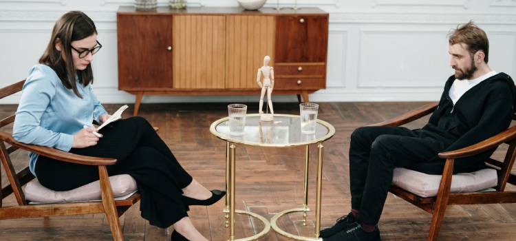 substance abuse counselor sitting across her patient looking at her notes