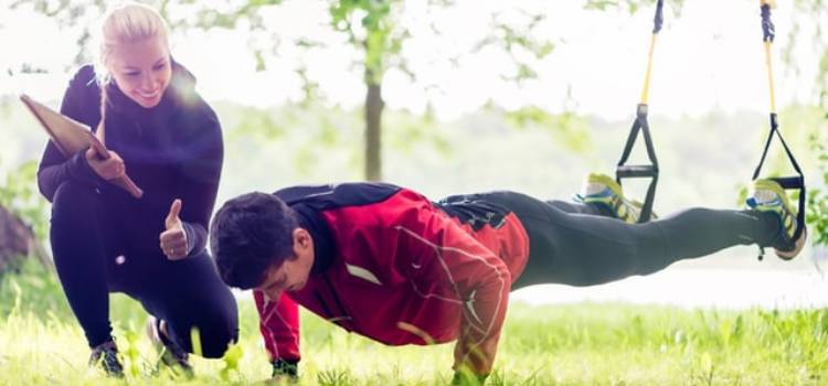 a personal trainer watching client perform elevated pushups