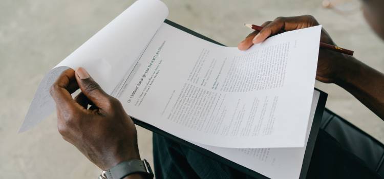 person sitting and reading through legal documents