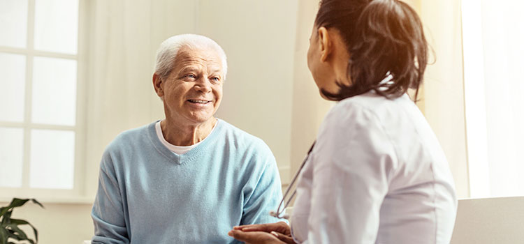 female community worker checks in and takes vitals of senior citizen