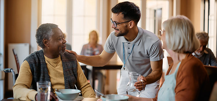 community health worker checking up on seniors in dining hall