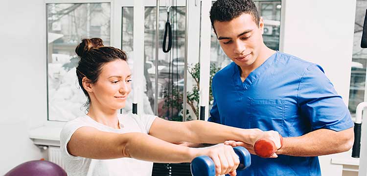 physical therapist tests woman clients arm strength