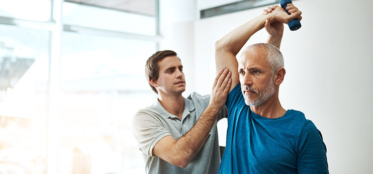 physical therapist works on shoulder alignment on male client