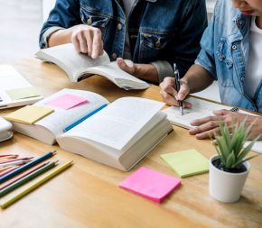 two people study together for an exam at a desk