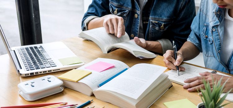two people study together for an exam at a desk